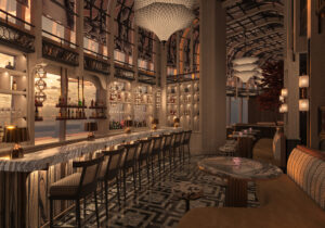 Elegant bar interior with a long marble counter, high-backed stools, warm lighting, decorative ceiling, and large windows overlooking a sunset view. Shelves with bottles and glasses line the stylish, sophisticated space.